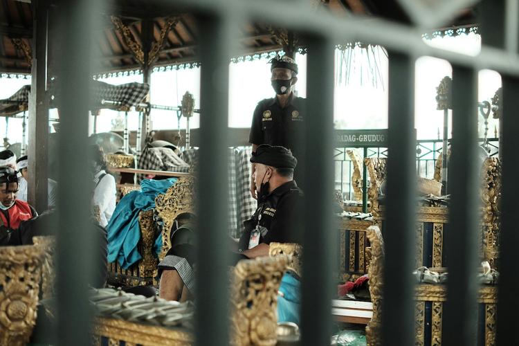deux officiers de sécurité à bali pris depuis une grille avec des barreaux