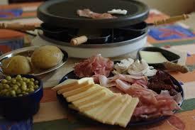 Une raclette sur la table avec fromage et appareil 