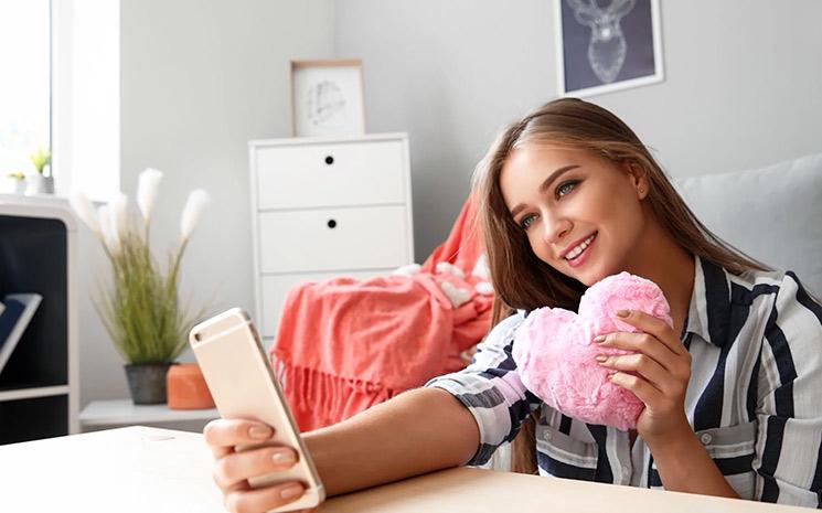 fille qui tient un coeur devant son smartphone 