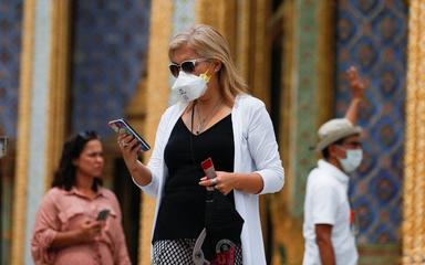 Une touriste devant un temple en Thailande