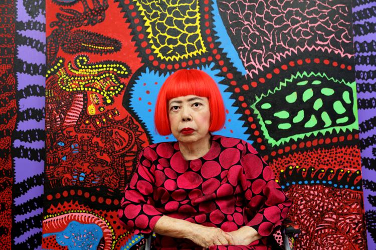 Portrait de Yayoi Kusama devant une de ses oeuvres