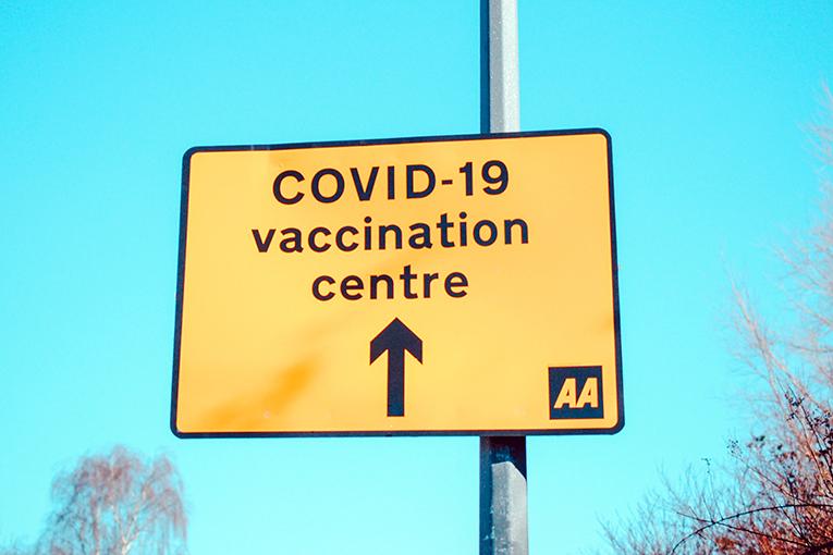 Un panneau qui indique la direction à suite pour aller au centre de vaccination contre la covid-19