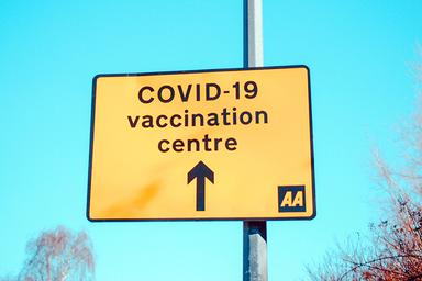 Un panneau qui indique la direction à suite pour aller au centre de vaccination contre la covid-19