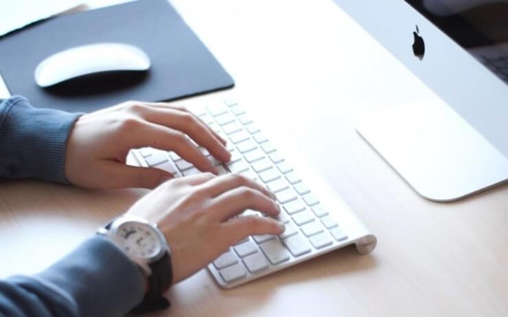 un homme écrit sur son clavier d'ordinateur