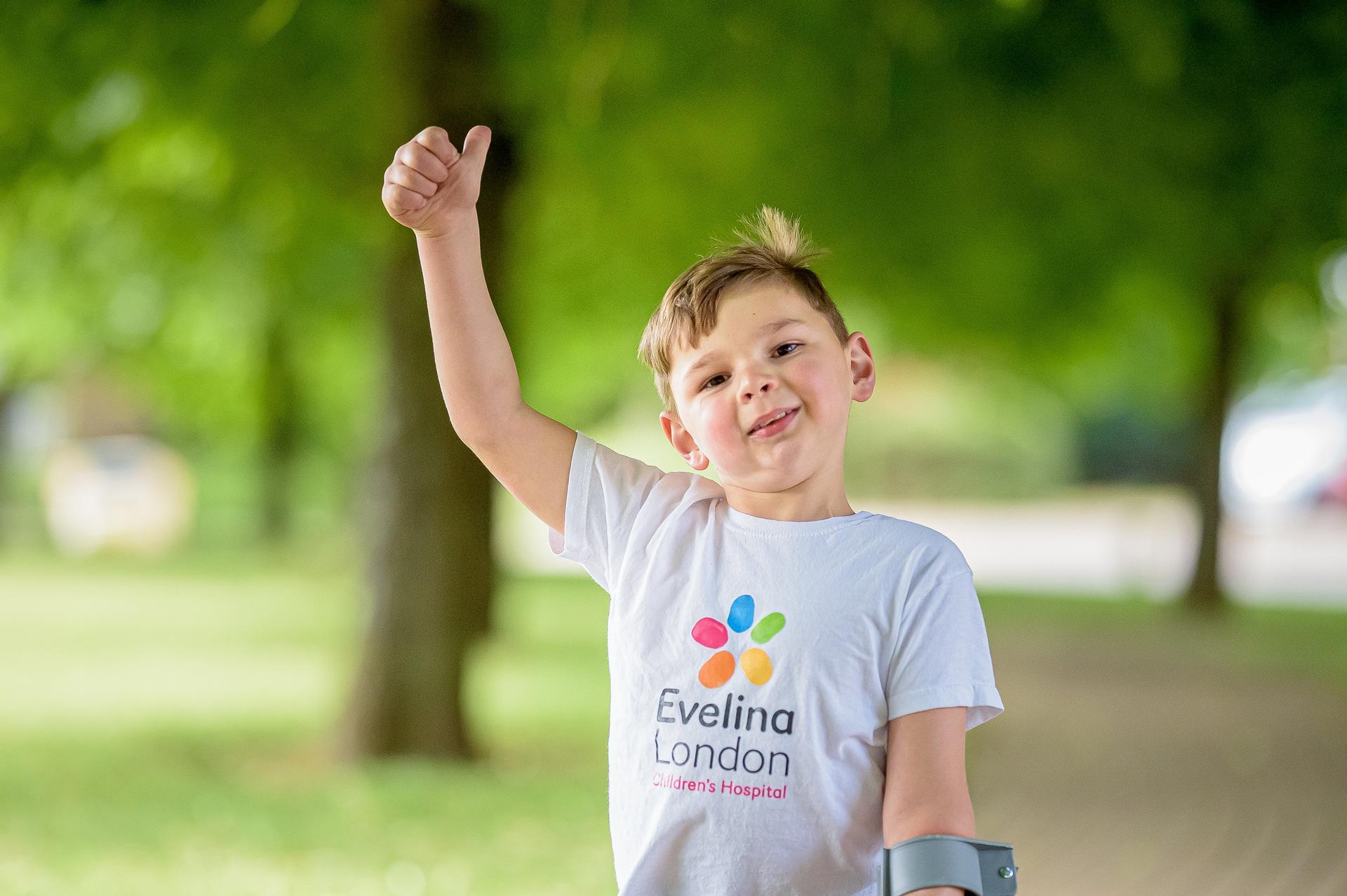 Tony Hudgell le pouce levé avec un t-shirt de l'hôpital pour enfants