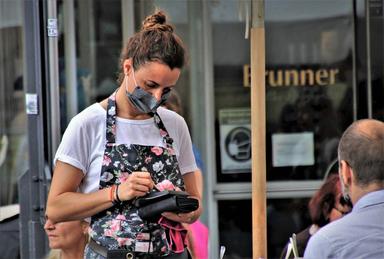 Une serveuse portant un masque prend une commande dans un restaurant de Bucarest