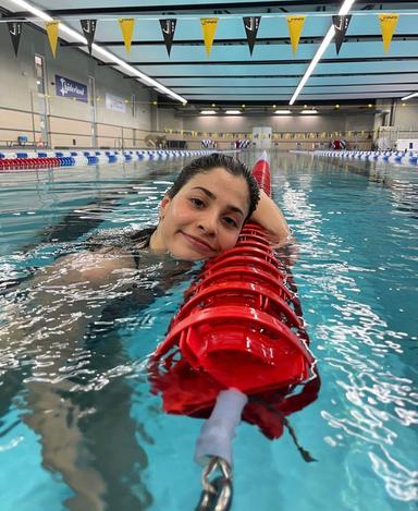 Yusra Mardini sourit à la caméra dans une piscine 