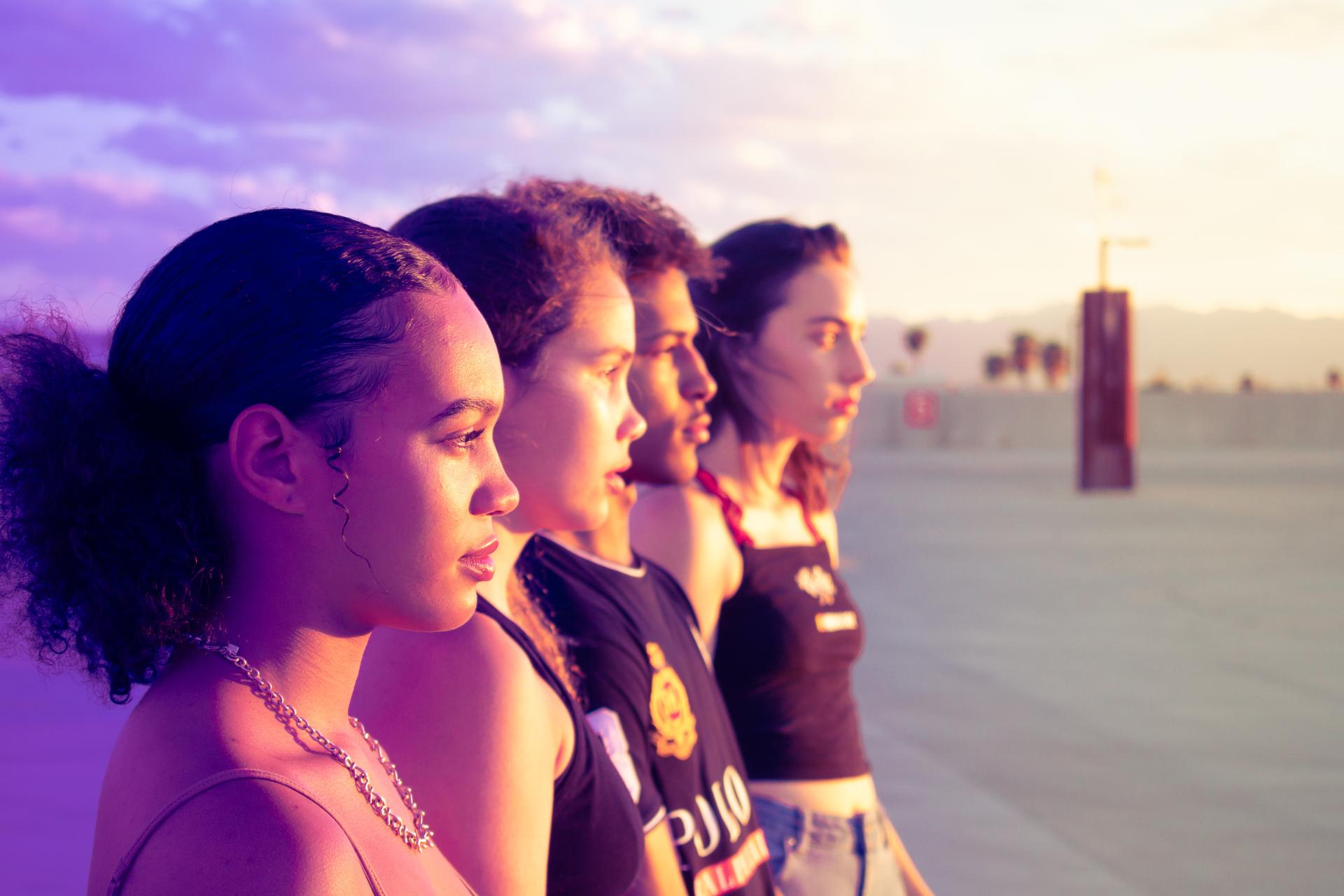 quatre jeunes personnes regardent ensemble vers l'horizon 