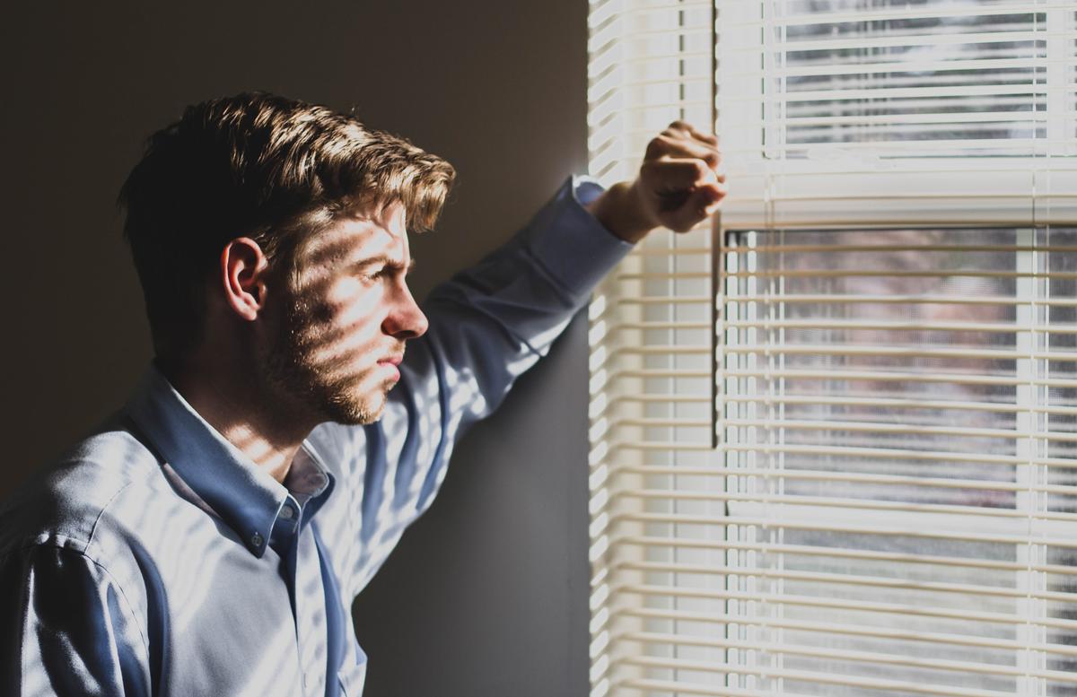 Un homme regarde par la fenêtre 