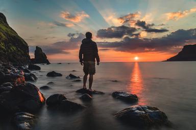 Un homme face à un coucher de soleil