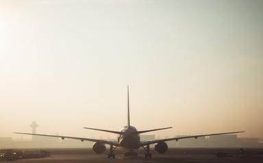 Un avion atterrissant au soleil couchant 