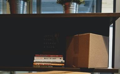 des livres et un carton de déménagement sur une étagère