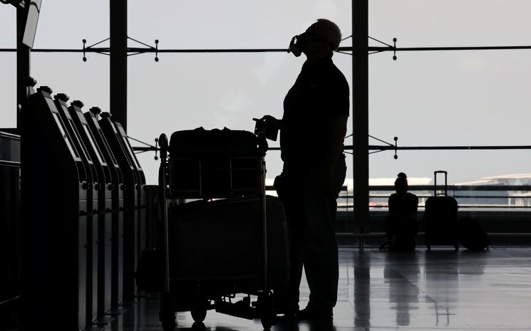 Un homme portant un masque facial dans l'aeroport thailandais Suvarnabhumi