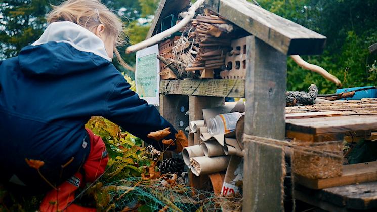 Une petite fille joue dans la cour d'une école à la rencontre de la biodiversité