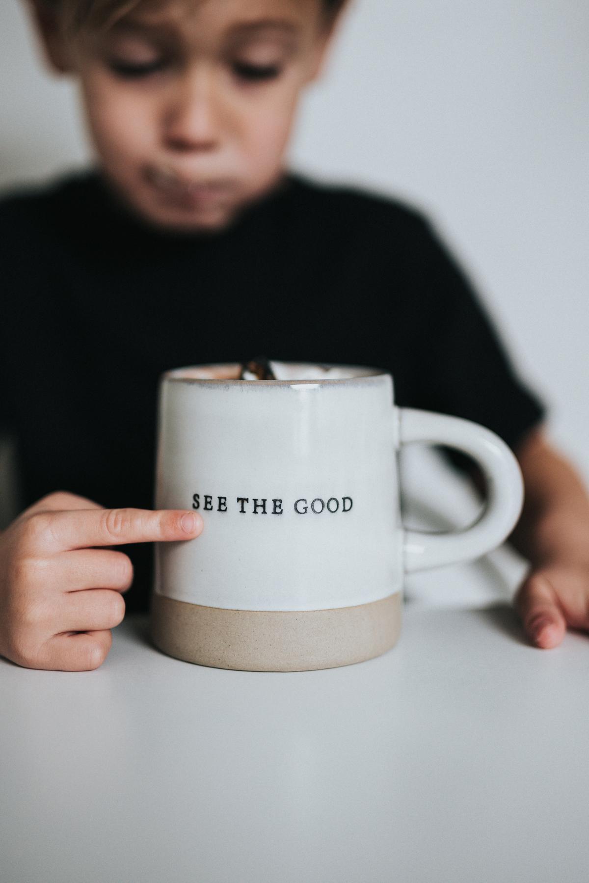 Un garçon montre une tasse du doigt