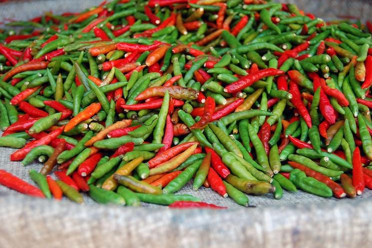 des piments rouges et verts sont mélangés sur une table