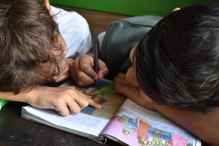 Deux écoliers lisant un livre