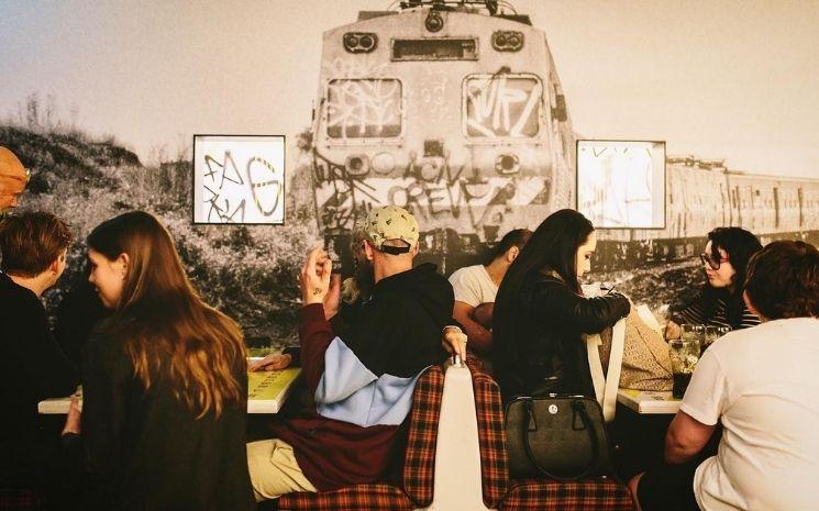 Des clients mangeant dans un des trains du restaurant Easey's