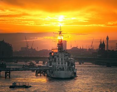 HMS Belfast : navire militaire transformé en musée sous un coucher de soleil Londonien.