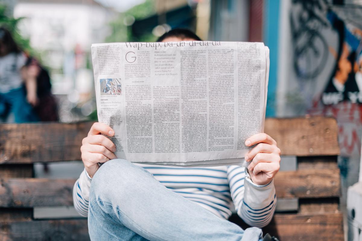 Une personne tenant un journal.