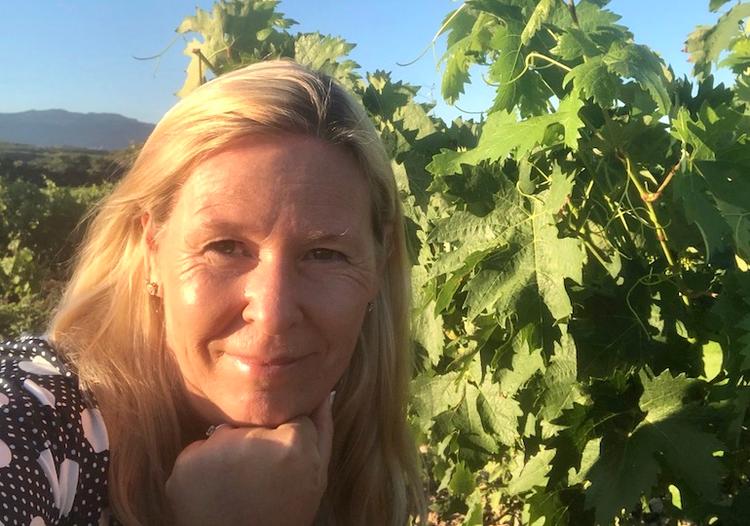 Une femme blonde au milieu des vignes