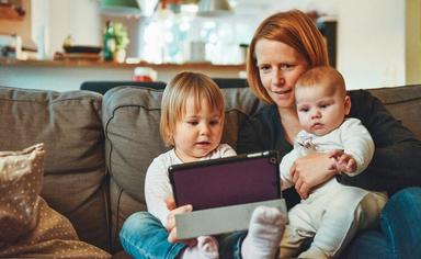 une maman avec ses deux enfants assis sur le canapé