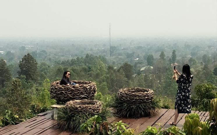 Des touristes prennent des photos avec la vallée de Chiang Mai embrumée par le smog