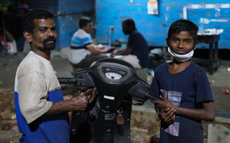 un père et son fils devant leur scooter