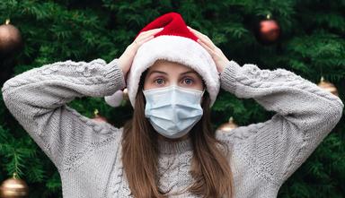 une jeune femme avec un chapeau de Noël et un masque hygiènique, en Catalogne