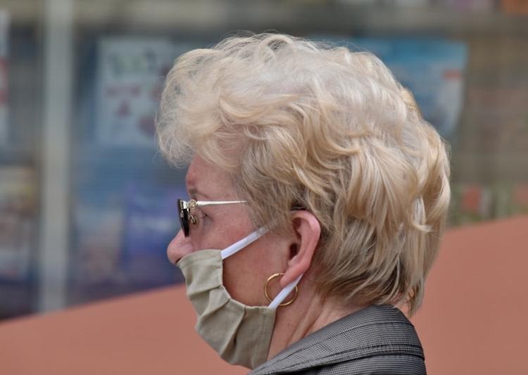 Une femme âgée qui porte un masque