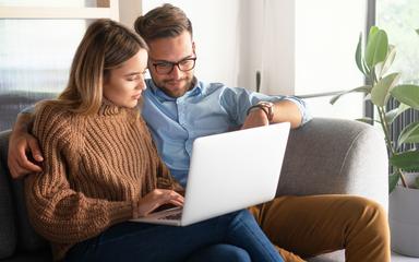 couple sur un canapé devant l'ordinateur