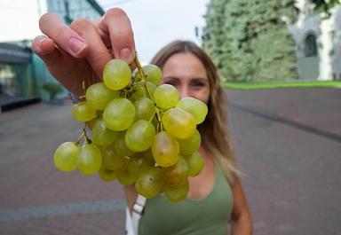 une jeune femme montre sa grappe de raisins avant le réveillon en Espagne