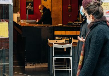 un couple passe devant un bar ouvert, à Barcelone