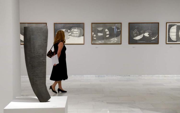 Une femme en train de regarder des tableaux dans un musée