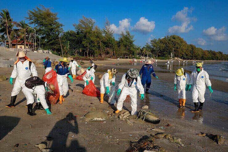 De nombreuses personnes nettoyant une plage en Thailande