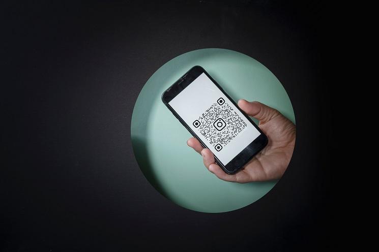 une personne montre un QR code sur son smartphone, en Espagne