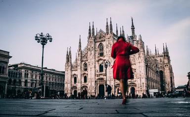 une femme en manteau rouge devant duomo de milan