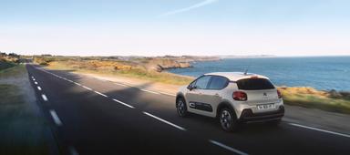 Voiture de location Citroën DS - TT sur une route de bord de mer