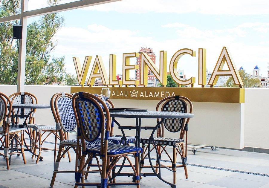 une terrasse avec des chaises bleues et des tables à Valencia