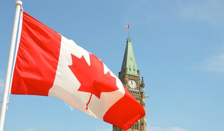 Le drapeau canadien avec un ciel bleu en fond