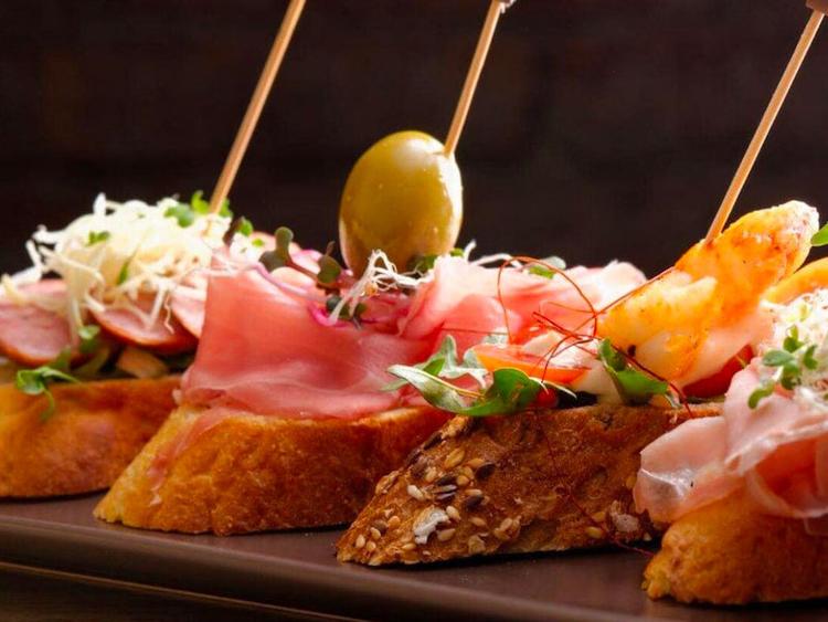 des pinchos avec du jambon et une olive