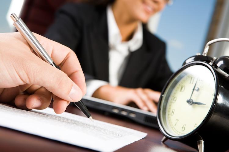 Des personnes travaillant dans un bureau avec un réveil matin en premier plan