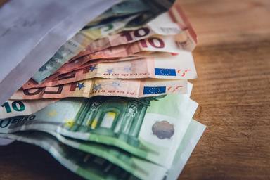 une liasse de billets sort d'une enveloppe