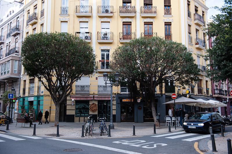 un immeuble jaune avec deux arbres