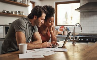 Un homme et une femme sur l'ordinateur dans leur cuisine