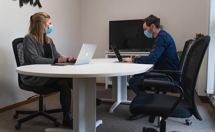 Deux personnes portent le masque au bureau 