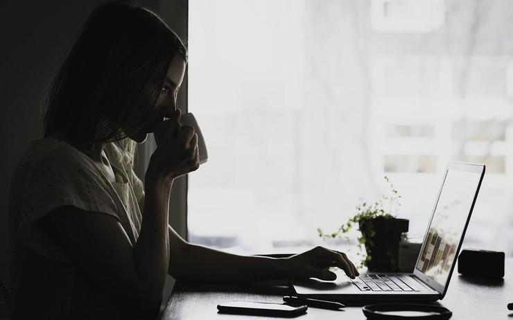 femme qui boit son café devant son ordinateur