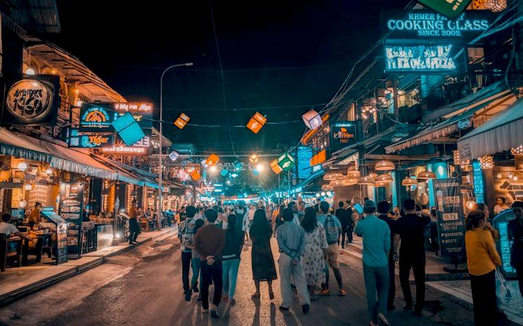 une rue éclairée et animée le soir au Cambodge 