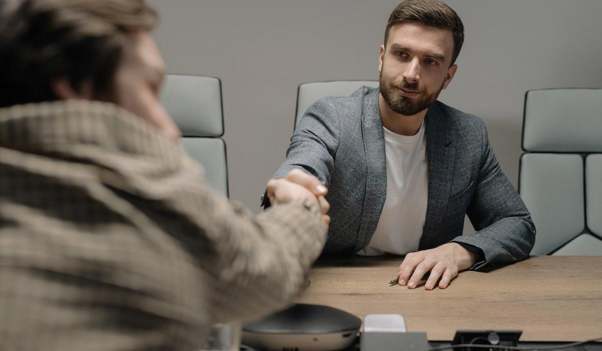 2 personnes se serrant la main dans un bureau 