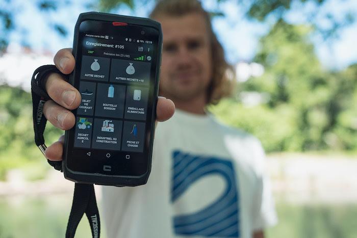 quelqu'un tend son téléphone avec l'Application plastic Origins